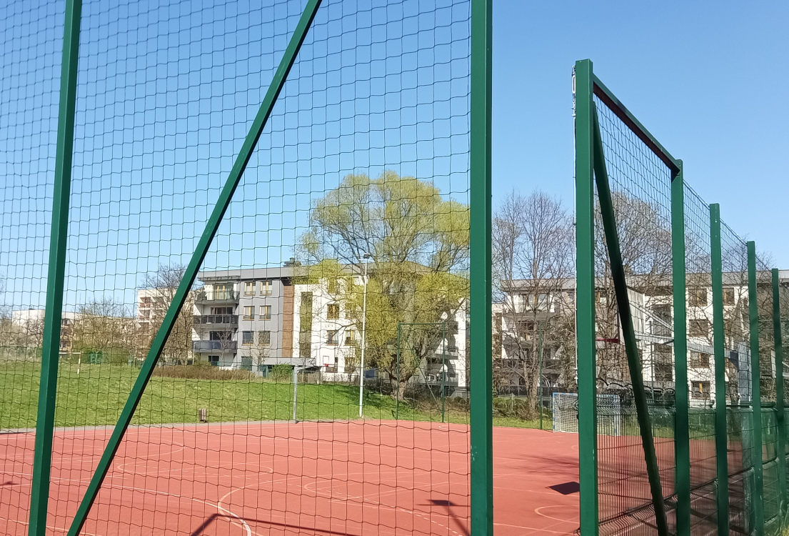 Montaż nowej siatki ochronnej na piłkochwytach przy boisku szkolnym